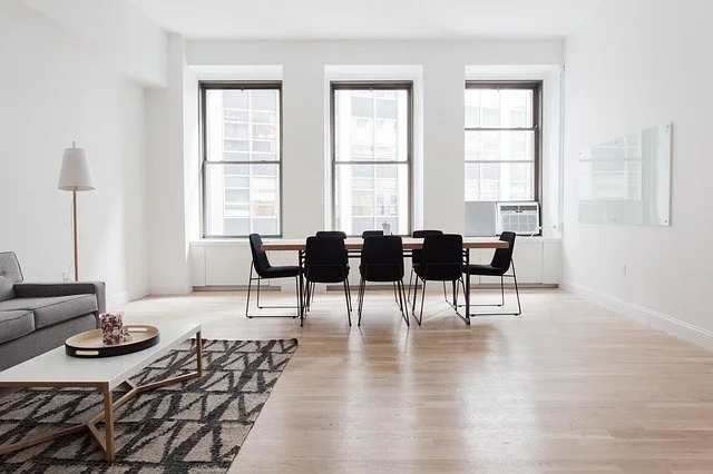 large room with big windows, table, chairs and rug